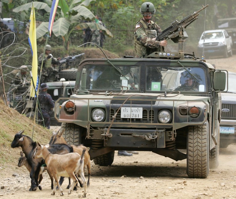 FILE - In this Saturday, March 3, 2007 file photo, a convoy of armed U.S. humvees stop as goats pass by  during the closing ceremonies of the annual military exercises called 