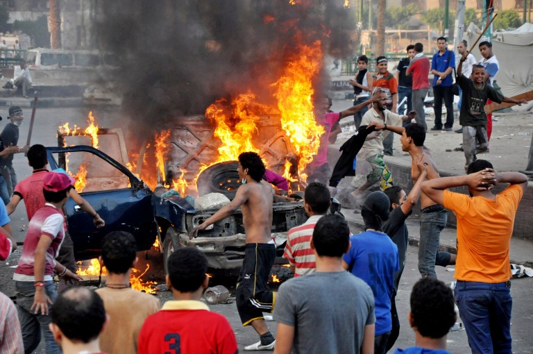 Egyptian protesters gather around a burning vehicle in downtown Cairo, Egypt, early Saturday, Sept. 15, 2012, before police cleared the area after days of protests against a film ridiculing the Prophet Muhammad. Egyptian police on Saturday cleared out protesters who have been clashing with security forces for the past four days near the U.S. Embassy as most cities around the Muslim world reported calm a day after at least six people were killed in a wave of angry protests over an anti-Islam film.(AP Photo)