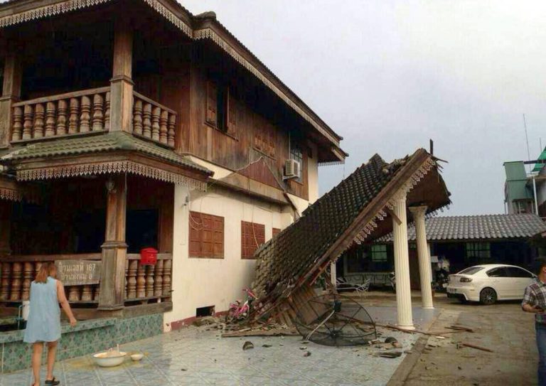 A woman looks at a partly damaged house following an earthquake in Chiang Rai province, northern Thailand Monday, May 5, 2014.  A strong earthquake shook northern Thailand and Myanmar on Monday evening, and some light damage was reported. (AP Photo)