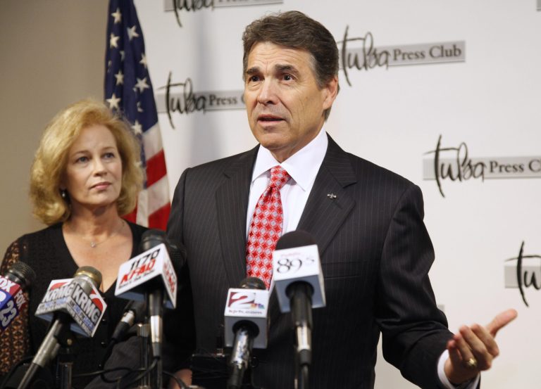 Texas Gov. Rick Perry gestures during recent news conference. Standing beside Perry is his wife, Angela.