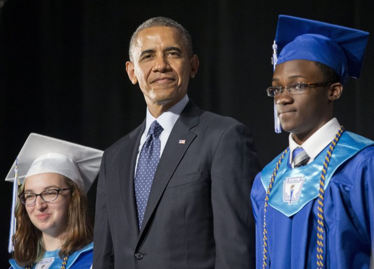 President Barack Obama, flanked by class Valedictorian Naomi Desilets, left, and student body President Reginald Sarpong,stands on stage prior to delivering the commencement address for Worcester Technical High School, Wednesday, June 11, 2014, in Worcester, Mass. (AP Photo/Pablo Martinez Monsivais)