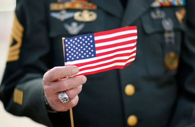 Army special forces vet Tony Junot holds an American flag during a Veterans Day ceremony Nov. 12, 2007 in Miami Beach, Florida. (Photo by Joe Raedle/Getty images)