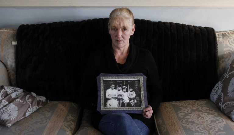 FILE - In this Thursday, Jan. 12, 2012, file photo, Helen McKendry holds a family photo with her mother, Jean McConville, at home in Killyleagh, Northern Ireland.  Police in Northern Ireland arrested Sinn Fein party leader Gerry Adams on Wednesday, April 30, 2014, over his alleged involvement in the Irish Republican Army's 1972 abduction, killing and secret burial of McConville. On Friday, May 2, the senior Sinn Fein politician in Northern Ireland's unity government demanded Adams' immediate release, as police sought to extend his interrogation over McConville's murder.  (AP Photo/Peter Morrison, File)