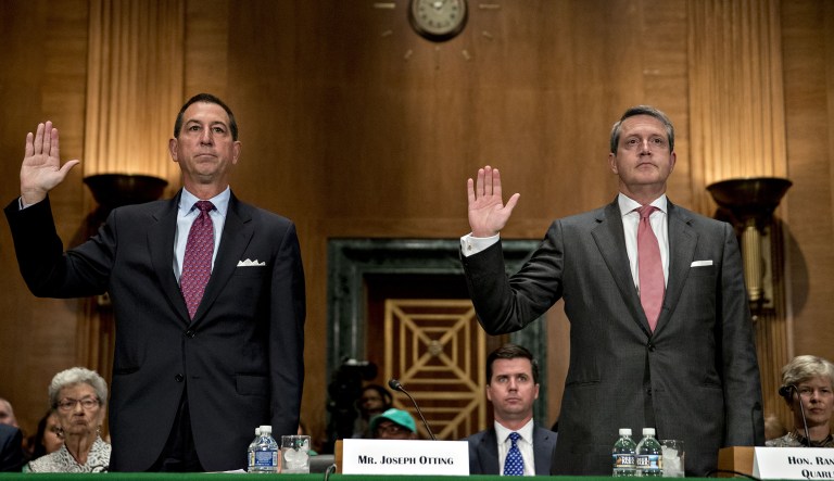 Joseph Otting, Comptroller of the Currency nominee, left, and Randal Quarles, governor of the U.S. Federal Reserve nominee, swear in to a Senate Banking Committee nomination hearing in Washington, D.C., U.S., on Thursday, July 27, 2017. Quarles and Otting will be the two most powerful U.S. banking regulators, setting them up to play leading roles in the Trump administrations efforts to roll back financial rules.(Andrew Harrer/Bloomberg)