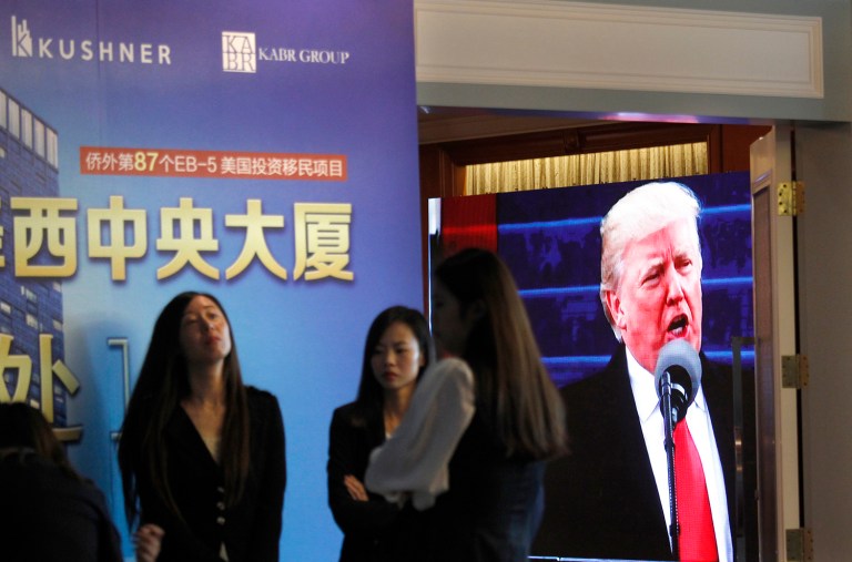 A projector screen shows a footage of President Donald Trump as workers wait for investors at a reception desk during an event promoting investment in a Kushner Companies development at a hotel in Shanghai, China, Sunday, May 7, 2017. The presentation mentioned the family’s fame and indirectly touted its closeness to President Trump as a positive. In a statement, the company indicated that was not its intention. (AP Photo)
