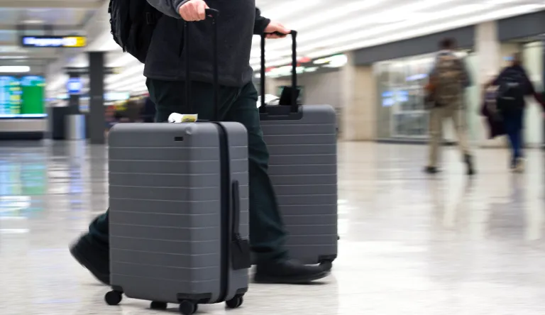 In this March 26, 2019, file photo, an airline passenger walk in the arrivals terminal at Dulles International Airport in Dulles, Va.