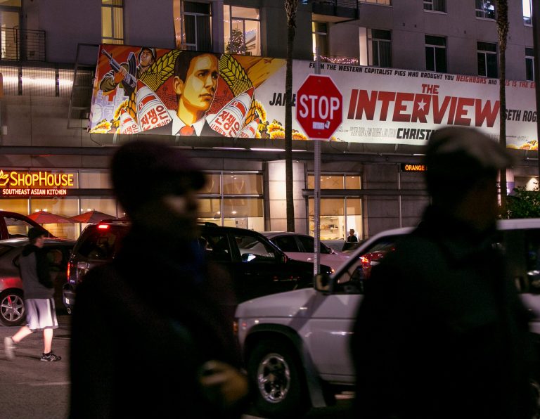 People walk past a banner for 