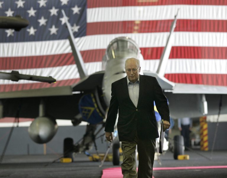 A Navy F/A-18 fighter jet is seen in the background as Vice President Dick Cheney arrives to greet sailors and Marines at a rally aboard the USS John C. Stennis aircraft carrier in the Persian Gulf, Friday, May 11, 2007. (AP Photo/Gerald Herbert)