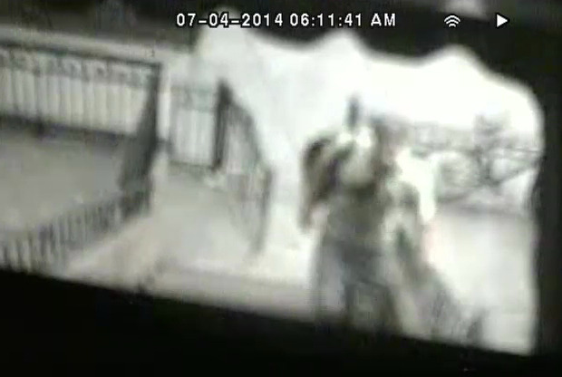 In this July 4, 2014 image taken from surveillance video and released by the New York City Police Department, a man climbs the front stairs of a residence in the Brooklyn borough of New York to steal an American flag. Police believe the man stole seven flags in the early morning hours of Friday, July 4, as Americans prepared to celebrate Independence Day. (AP Photo/New York City Police Department)