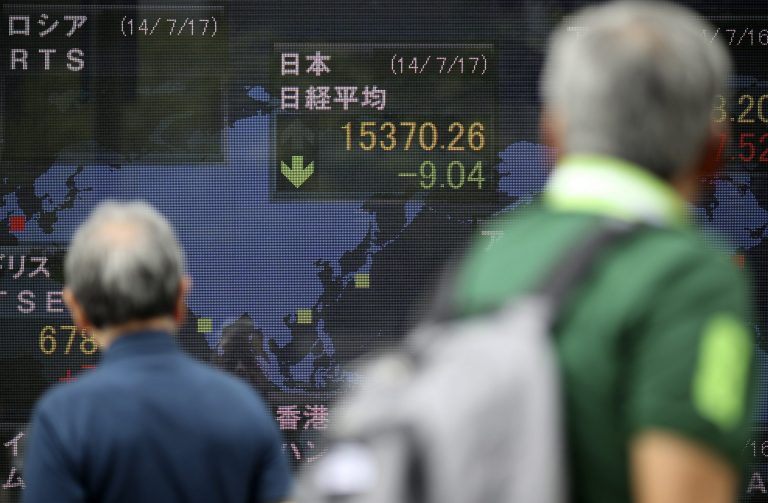 Pedestrians look at an electronic stock board of a securities firm in Tokyo, Thursday, July 17, 2014. Asia's major stock markets mostly posted modest gains Thursday after positive U.S. corporate and economic news underpinned confidence. (AP Photo/Eugene Hoshiko)