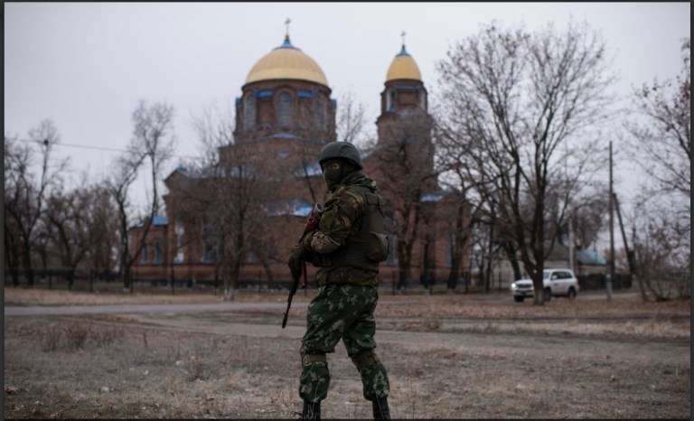 A Ukrainian serviceman patrols the center of Trehizbenka village, controlled by Ukrainian government forces, in Luhansk region eastern Ukraine, Sunday, Nov. 23, 2014. More than 4,300 people have died in fighting in eastern Ukraine over the past half year, according to U.N. estimates. (AP Photo/Evgeniy Maloletka)