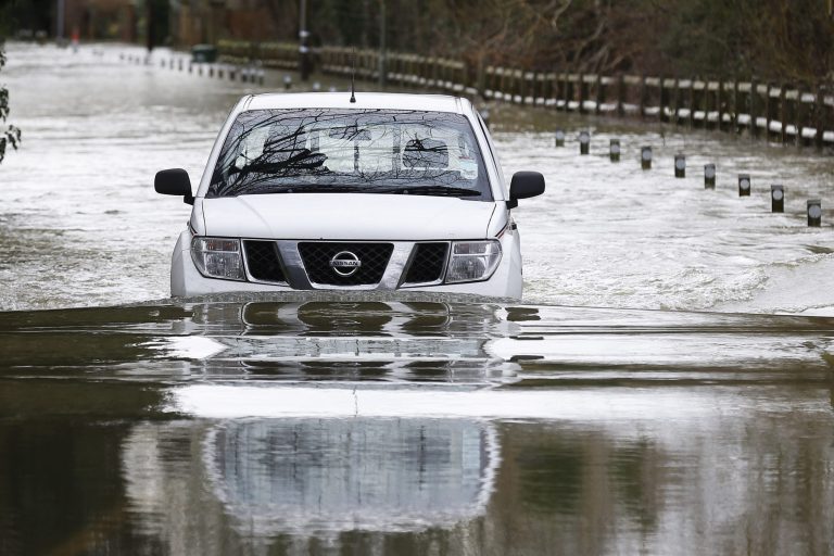 A car drives through a flooded road  in Shepperton, England, Tuesday, Feb. 11, 2014. The River Thames has burst its banks after reaching its highest level in years, flooding riverside towns upstream of London. The River Thames has burst its banks after reaching its highest level in years, flooding riverside towns upstream of London. Residents and British troops piled up sandbags to protect properties from the latest bout of flooding, but the river overwhelmed their defenses in several places Monday, leaving areas underwater. (AP Photo/Sang Tan)