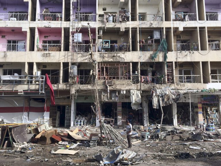 Iraqi civilians inspect the aftermath of a car bombing in the southeastern district of New Baghdad, Iraq, Sunday, June 8, 2014. A series of car bombs exploded across Iraq's capital Saturday night, killing and wounding people, in a day of violence that saw militants storm a university in the country's restive Anbar province and take dozens hostage, authorities said. (AP Photo/Khalid Mohammed)