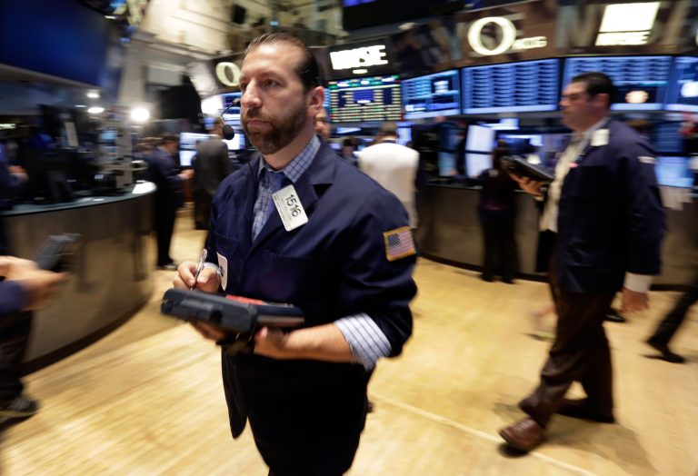 Trader Greg Mulligan, left, works on the floor of the New York Stock Exchange Wednesday, July 9, 2014.  Stocks inched higher in early trading Wednesday, reversing a two-day decline, as the quarterly earnings season got underway with some positive news from the giant aluminum company Alcoa. (AP Photo/Richard Drew)