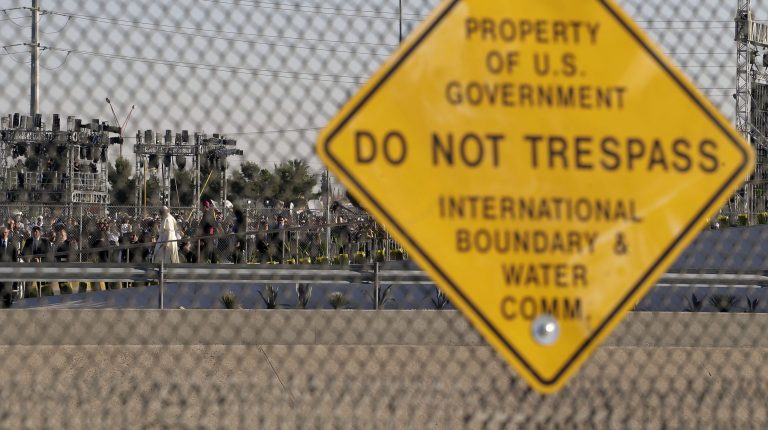 Pope Francis is seen through a border hence in El Paso, Texas as he walks down a praying platform on the banks of the Rio Grande in Juarez, Mexico, Wednesday, Feb. 17, 2016. (AP Photo/Eric Gay)