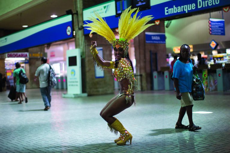 In this photo taken Saturday, Feb. 2, 2013, samba dancer Diana Prado performs during a carnival parade at central station in Rio de Janeiro, Brazil. Prado spends her daylight hours working as a supervisor at a call center. At night, she is a samba dancer, or 