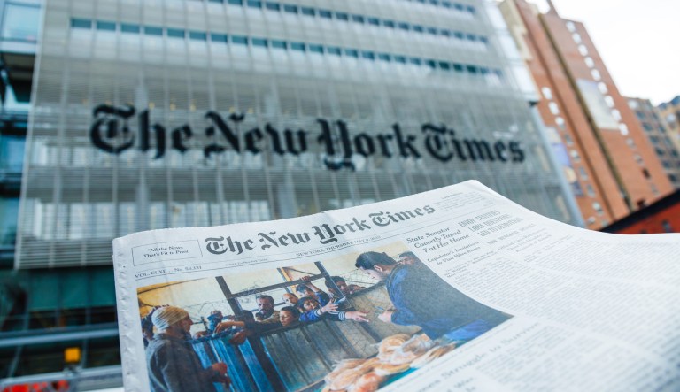 A The New York Times newspaper in front of The New York Times company office building at 620 8th Avenue, Midtown Manhattan, New York City. 