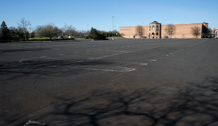 The shadow of a tree is cast on an empty parking lot of the closed Willow Grove Park Mall in Willow Grove, Pa., Monday, March 16, 2020.
