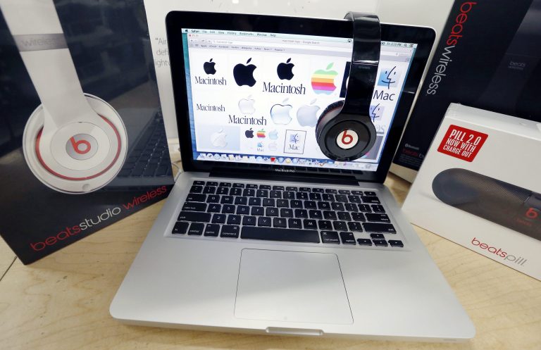 FILE - In this May 9, 2014 file photo, Beats Audio equipment is arranged for a photo next to an Apple laptop at Best Buy in Boston. Apple announced Wednesday, May 28, 2014, that it is acquiring Beats Electronics for $3 billion. Beats, the headphone and music streaming specialist, also brings the swagger of rapper Dr. Dre and recording impresario Jimmy Iovine. (AP Photo/Michael Dwyer, File)