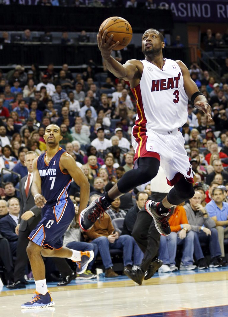   Miami Heat's Dwyane Wade (3) drives past Charlotte Bobcats' Ramon Sessions (7) after being fouled during the second half of an NBA basketball game in Charlotte, N.C., Wednesday, Dec. 26, 2012. Miami won 105-92. (AP Photo/Chuck Burton)  