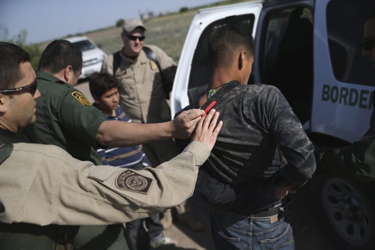 U.S. Border Patrol and U.S. Air and Marine agents work together to detain an undocumented immigrant after chasing him down near the U.S.-Mexico border on April 11, 2013 near Mission, Texas. (Photo by John Moore/Getty Images)