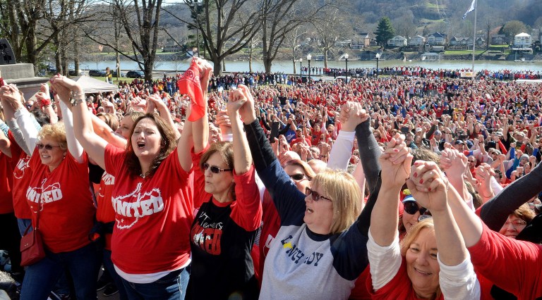 Striking teachers grasp hands during a rally at the West Virginia Capitol in Charleston. (Chris Dorst/Charleston Gazette-Mail via AP)