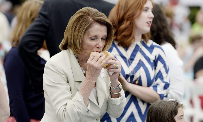 House Minority Leader Nancy Pelosi eats a hamburger at a picnic for members of Congress on the South Lawn of the White House June 17, 2015 in Washington, D.C. The annual summer event was revived this year after being pushed back and then canceled last summer. (Photo by Olivier Douliery-Pool/Getty Images)
