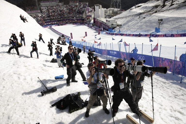 Photographers take pictures during the men's and women's snowboard parallel slalom quarterfinals at the Rosa Khutor Extreme Park, at the 2014 Winter Olympics, Saturday, Feb. 22, 2014, in Krasnaya Polyana, Russia. (AP Photo/Jae C. Hong)