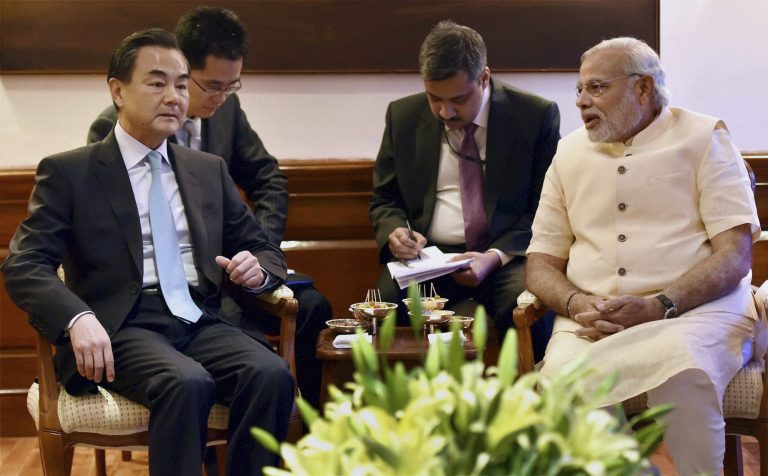 FILE - In this Monday, June 9, 2014 file photo, visiting Chinese Foreign Minister Wang Yi, left, sits with Indian Prime Minister Narendra Modi, right during their meeting in New Delhi, India. Amid fierce disputes with Japan, Vietnam and the Philippines, China is reaching out in a friendly way to India in a warming trend that could help ramp up economic exchanges and dissipate decades of distrust between the two giant neighbors. (AP Photo, File)