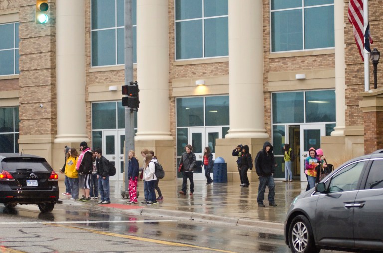   Battle Creek Central High School students wait to cross Van Buren Ave., after school ended for the day Thursday, Dec. 20, 2012 in Battle Creek, Mich. Dozens of Michigan schools canceled classes for thousands of students to cool off rumored threats of violence and problems related to doomsday scenarios based on the Mayan calendar, officials said Thursday. (AP Photo/Battle Creek Enquirer, Robert Youngs Jr.)  