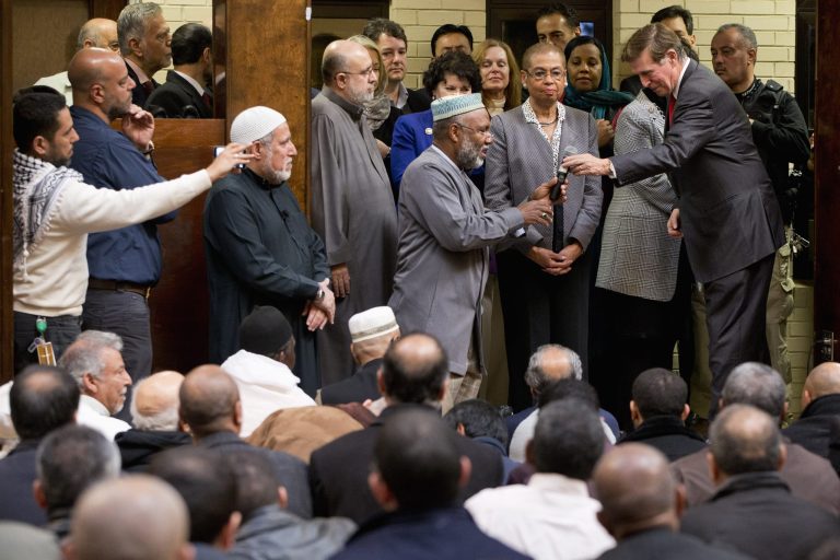 Rep. Don Beyer, D-Va., right, next to Del. Eleanor Holmes Norton, D-D.C., center, takes a microphone from Imam Johari Abdul-Malik, before speaking after attending Friday prayers at Dar al-Hijrah Mosque in Falls Church, Va. on Friday. (AP Photo/Jacquelyn Martin)