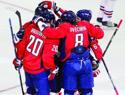 Washington Capitals' Troy Brouwer (20), Alex Ovechkin (8), of Russia, and Dennis Wideman (6) celebrate their first goal against the Columbus Blue Jackets during the first period of an NHL preseason hockey game, Monday, Sept. 26, 2011, in Washington. (AP Photo/Charles Dharapak)