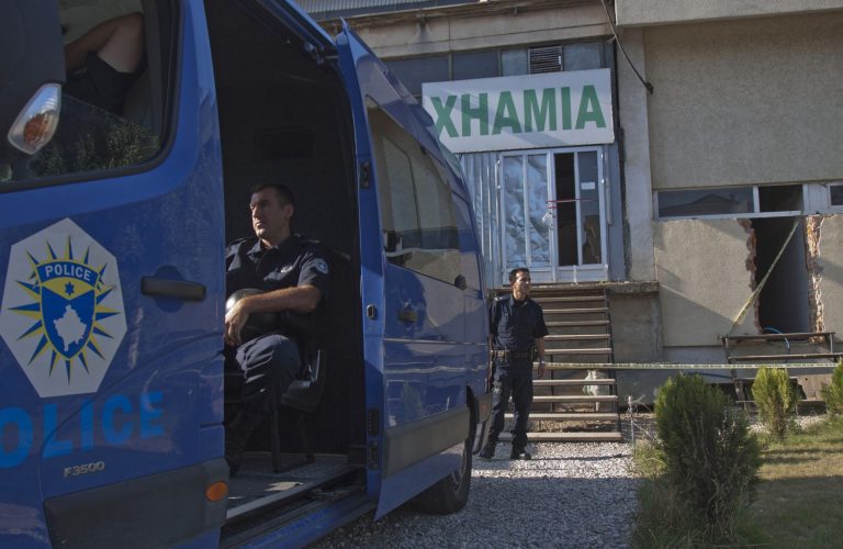 Kosovo police officers guard the entrance of a makeshift mosque after raid in Kosovo capital Pristina on Monday, Aug. 11, 2014. Kosovo police arrested at least 40 people in a major operation targeting Islamic radicals suspected of fighting alongside extremists in Iraq and Syria. Weapons, ammunition and explosives were seized early Monday as hundreds of police officers and special police units raided 60 locations across Kosovo, including makeshift mosques believed to have served as recruiting centres.  Sign in background 