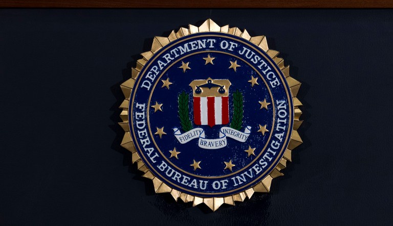 FILE - In this June 14, 2018, file photo, the FBI seal is seen before a news conference at FBI headquarters in Washington. The FBI is grappling with a seemingly endless cycle of money laundering schemes that law enforcement officials say theyâre scrambling to slow through a combination of prosecution and public awareness. Beyond the run-of-the-mill plots, officials say, is a particularly concerning trend involving âmoney mules.â These are people who, unwittingly or not, use their own bank accounts to move money for criminals for purposes they think are legitimate or even noble.