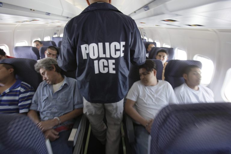 Immigration and Customs Enforcement agent walks down the aisle among shackled Mexican immigrants a boarded a U.S. Immigration and Customs Enforcement charter jet for deportation in the air between Chicago, Il. and Harlingen, Texas. (AP Photo/LM Otero)