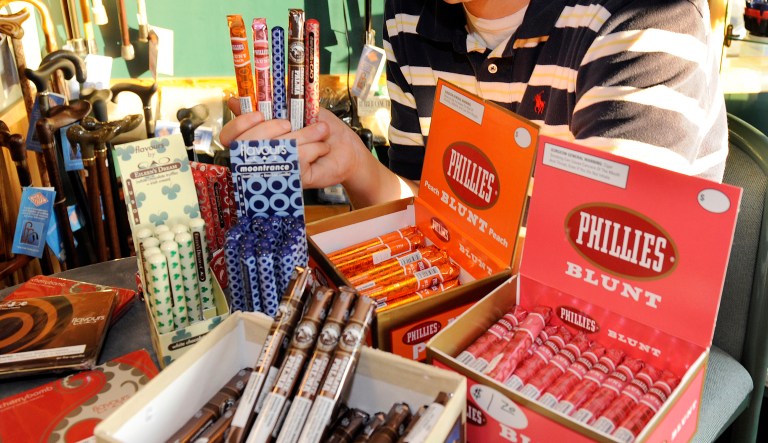 Cigar enthusiast Brendan Glennon poses with a display of candy flavored cigars at a custom tobacco shop in Albany, N.Y., Friday, May 31, 2013.