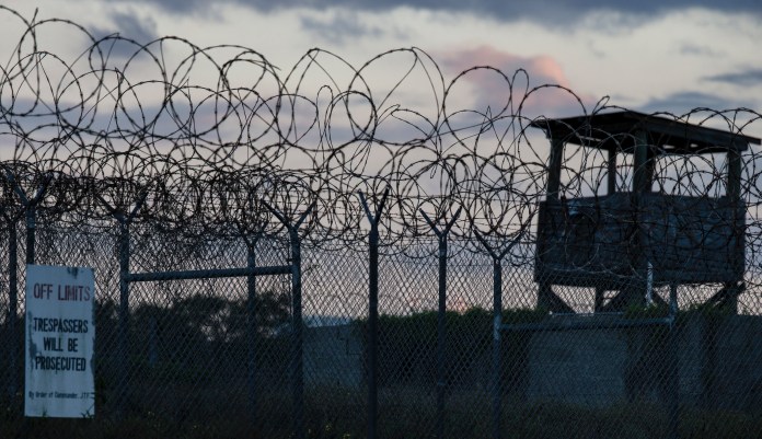 In this photo reviewed by U.S. military officials, the sun sets behind the closed Camp X-Ray detention facility, Wednesday, April 17, 2019, in Guantanamo Bay Naval Base, Cuba. 