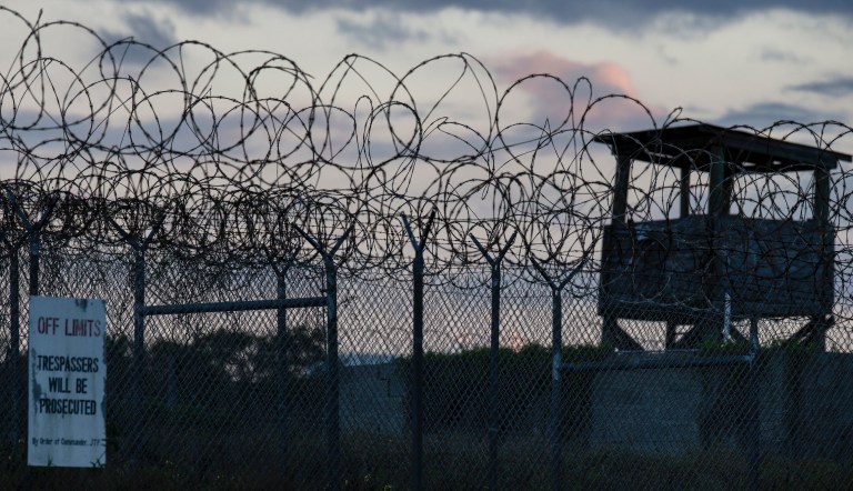 In this photo reviewed by U.S. military officials, the sun sets behind the closed Camp X-Ray detention facility, Wednesday, April 17, 2019, in Guantanamo Bay Naval Base, Cuba. 
