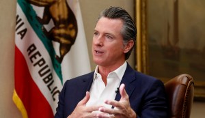 California Gov. Gavin Newsom, left, flanked by Attorney General Xavier Becerra, right, answers a question concerning a  lawsuit the state will likely file against President Donald Trump over his emergency declaration to fund a wall on the U.S.-Mexico border Friday, Feb. 15, 2019, in Sacramento, Calif.
