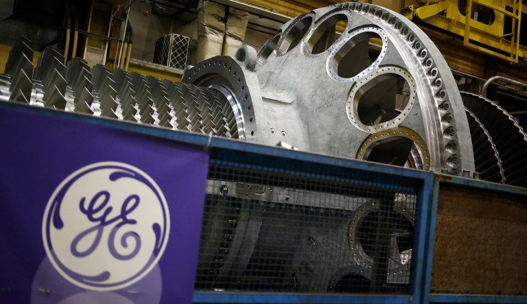 A logo is displayed next to a gas turbine at the General Electric Co. (GE) energy plant in Greenville, South Carolina, U.S., on Tuesday, Jan. 10, 2017. General Electric Co. is scheduled to release earnings figures on January 20.