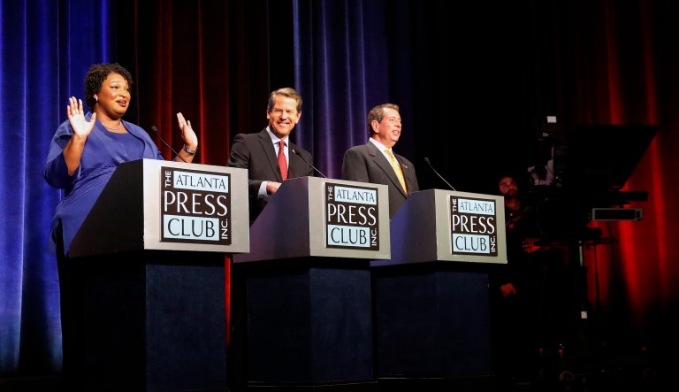 Candidates for Georgia governor Democrat Stacey Abrams, Republican Sec. of State Brian Kemp, and Libertarian Ted Metz react as an alarm interrupts a debate, Tuesday, Oct. 23, 2018, in Atlanta. 
