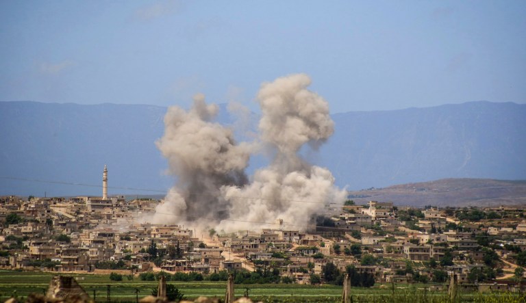 In this May 3, 2019 file photo, provided by the Syrian Civil Defense White Helmets, which has been authenticated based on its contents and other AP reporting, shows smoke rising after Syrian government and Russian airstrikes that hit the town of al-Habeet, southern Idlib, Syria.