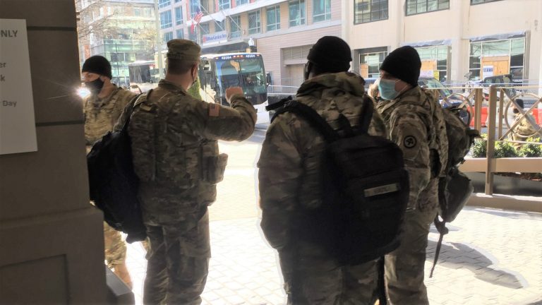 Some of the remaining 6,200 National Guard members providing capital security stand outside a Georgetown hotel where they are staying while providing support to law enforcement. The National Guard are expected to remain in the capital until mid-March