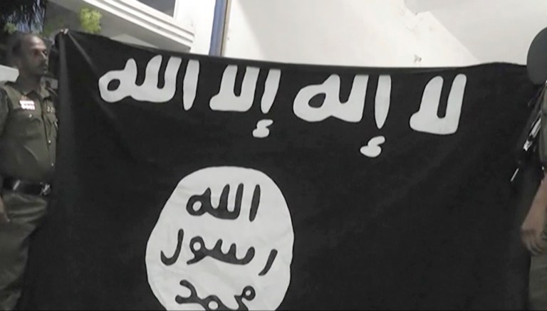 An Islamic State militant flag lies in a tent encampment after U.S.-backed Syrian Democratic Forces (SDF) fighters took control of Baghouz, Syria on Saturday, March 23, 2019. 
