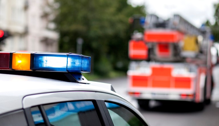 A police car and a fire engine truck appear on the scene of an emergency.