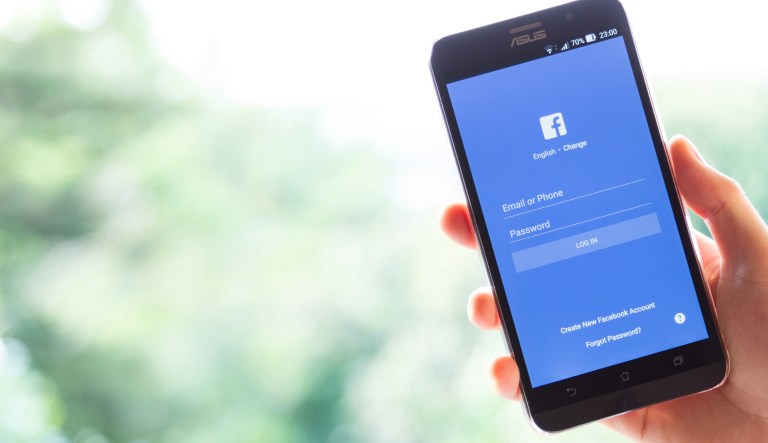 A hand holds a phone displaying a Facebook page in this March 28, 2016, photo.