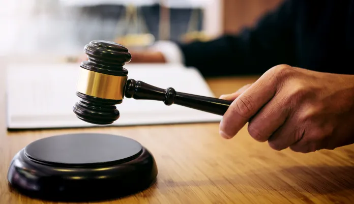 A person hits a flat surface with a gavel.