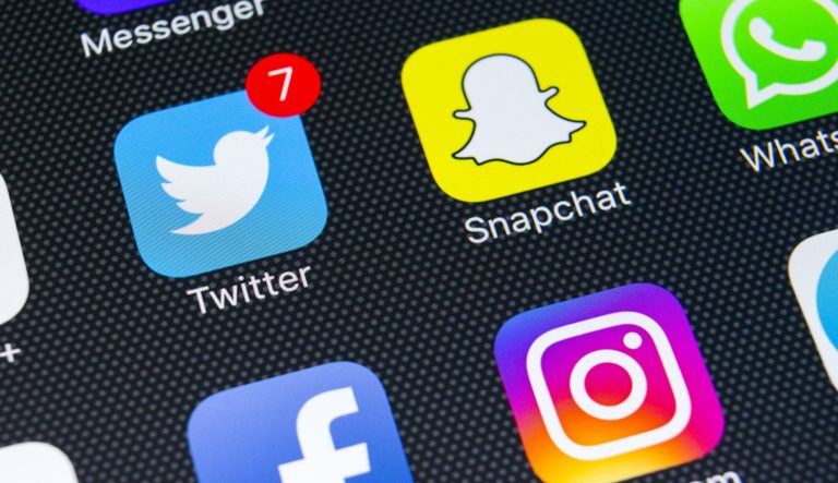 An Apple iPhone X with social media icons.