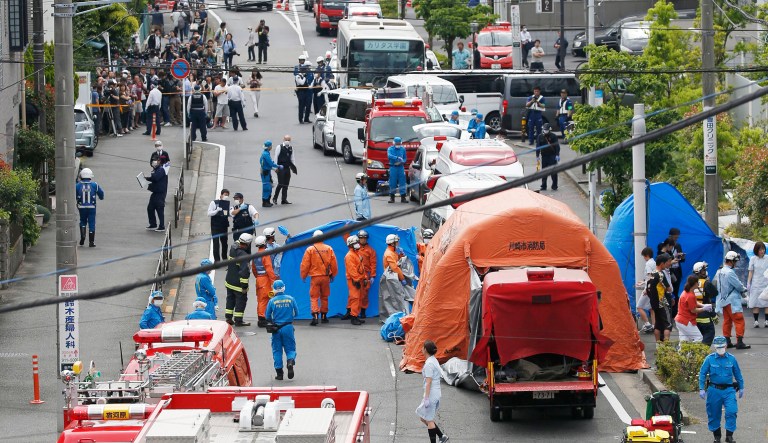 Rescuers work at the scene of an attack in Kawasaki, near Tokyo Tuesday, May 28, 2019. A man wielding a knife attacked commuters waiting at a bus stop just outside Tokyo during Tuesday morning's rush hour,  Japanese authorities and media said.