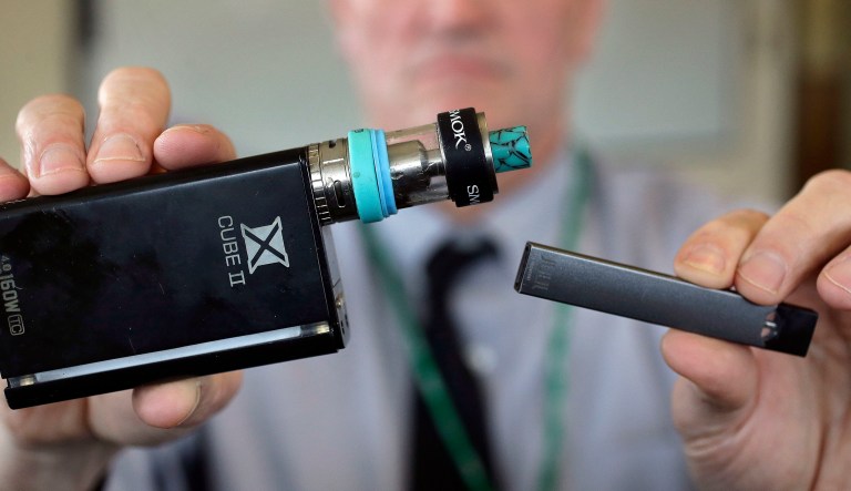 In this Monday, June 17, 2019, file photo, a cashier displays a packet of tobacco-flavored Juul pods at a store in San Francisco.